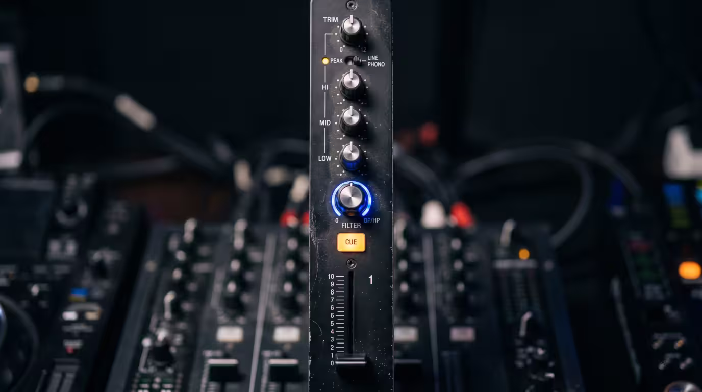 Close-up of one DJ mixer channel strip: trim, EQ, filter, fader and cue