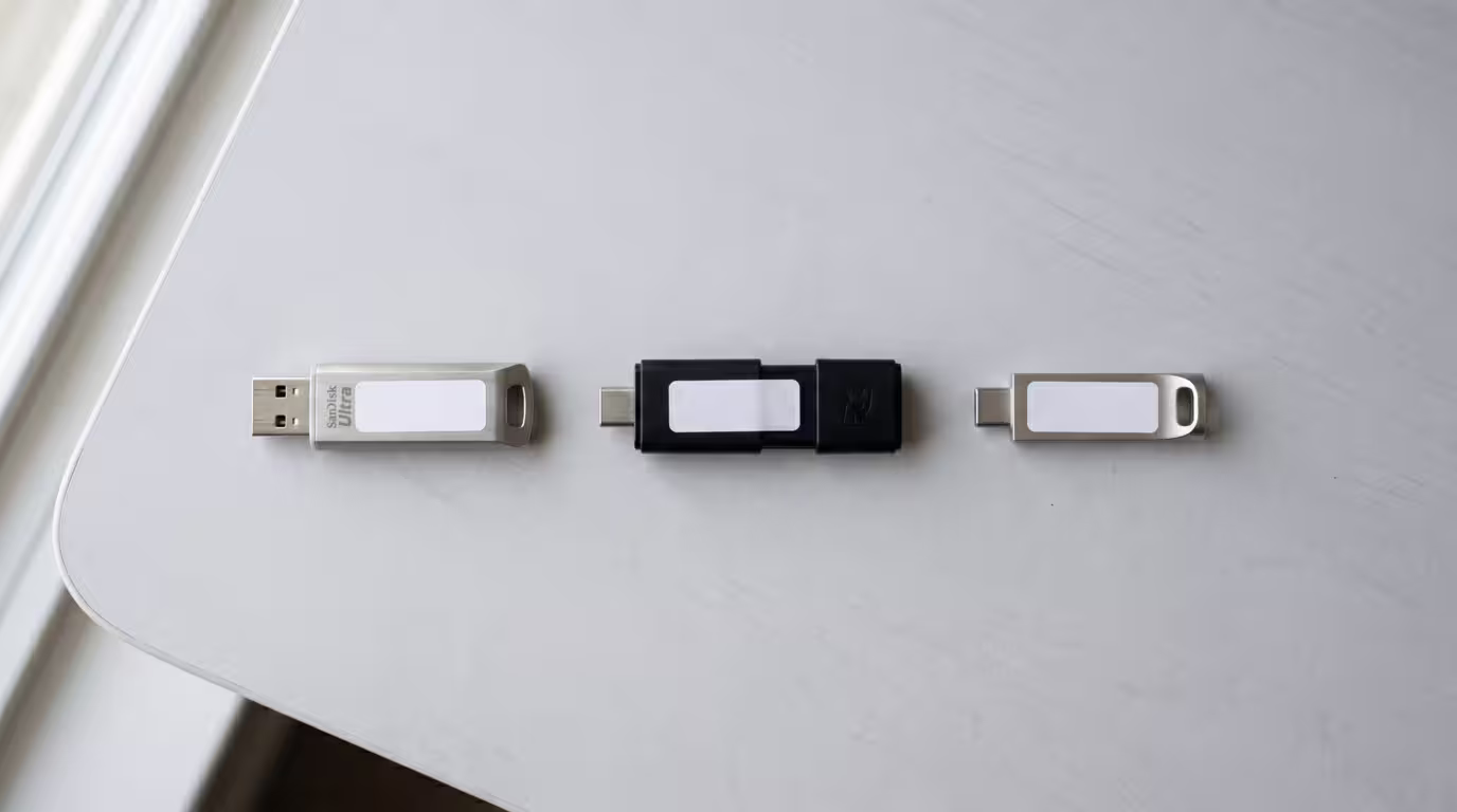 Three labeled USB sticks laid out on a neutral surface as backups