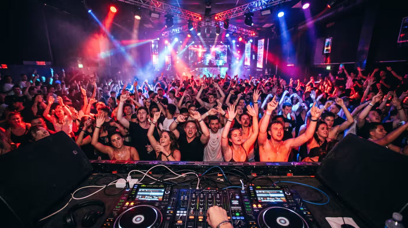 An energized, packed dancefloor with hands in the air