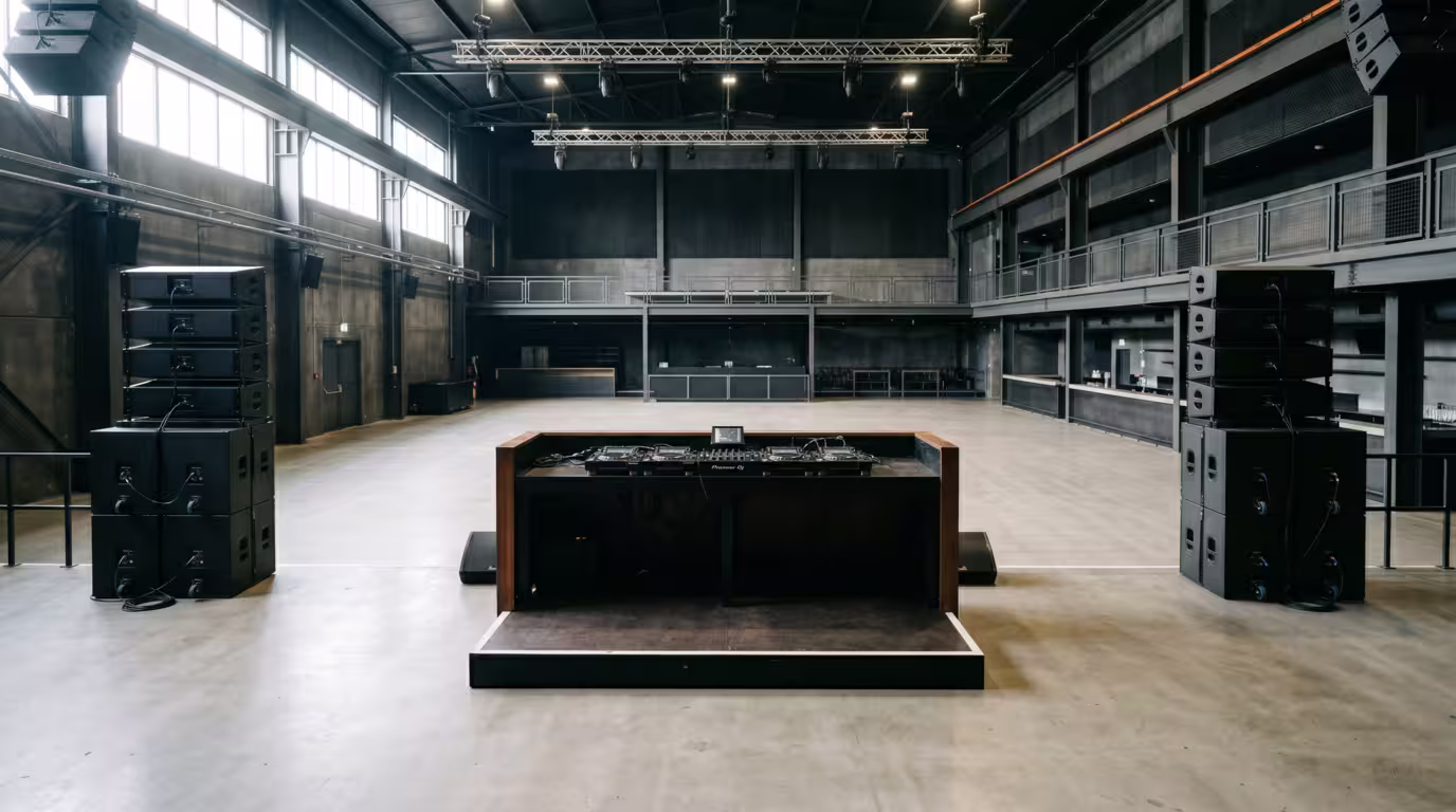 Empty club in daylight showing the DJ booth and PA before doors