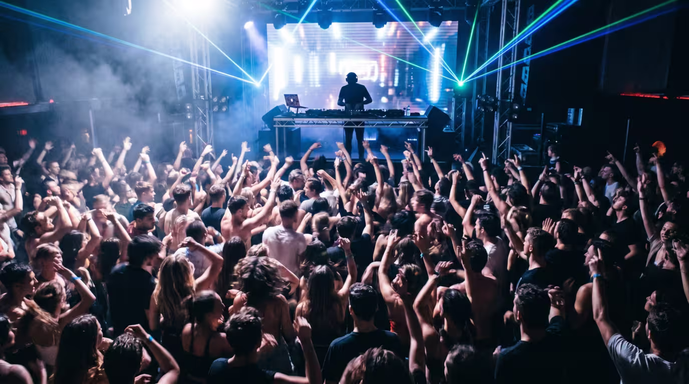 A packed dance floor at peak time with hands in the air and intense lighting